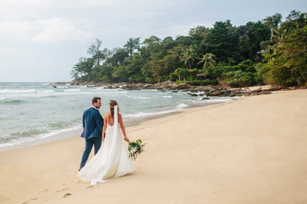 bride and groom walk down the beach at Thailand wedding venue Trisara Resort Phuket Thailand wedding
