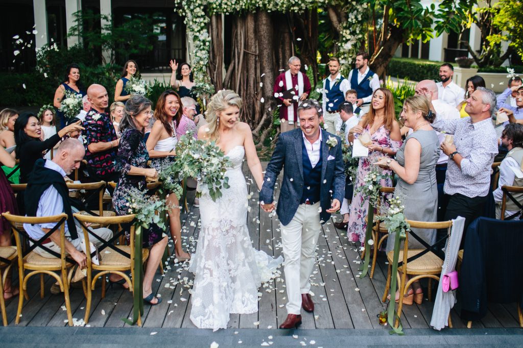 The bride and groom leave their wedding ceremony at 137 Pillars House Chiang Mai in Thailand.