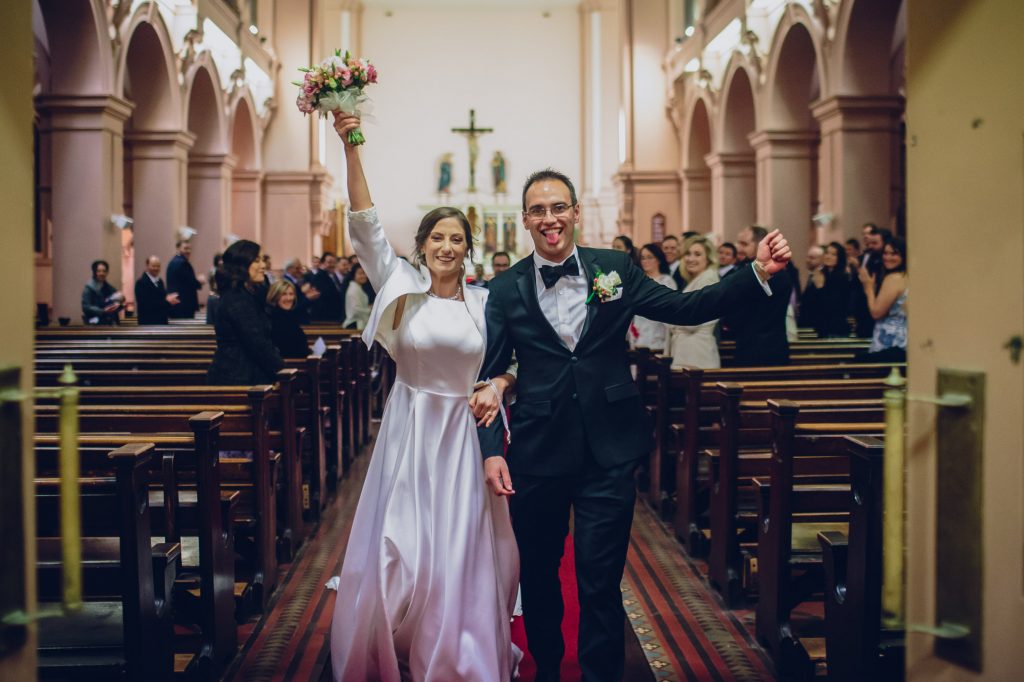 bride and groom leave together at Sacred Heart Catholic Church at their Melbourne wedding in Australia