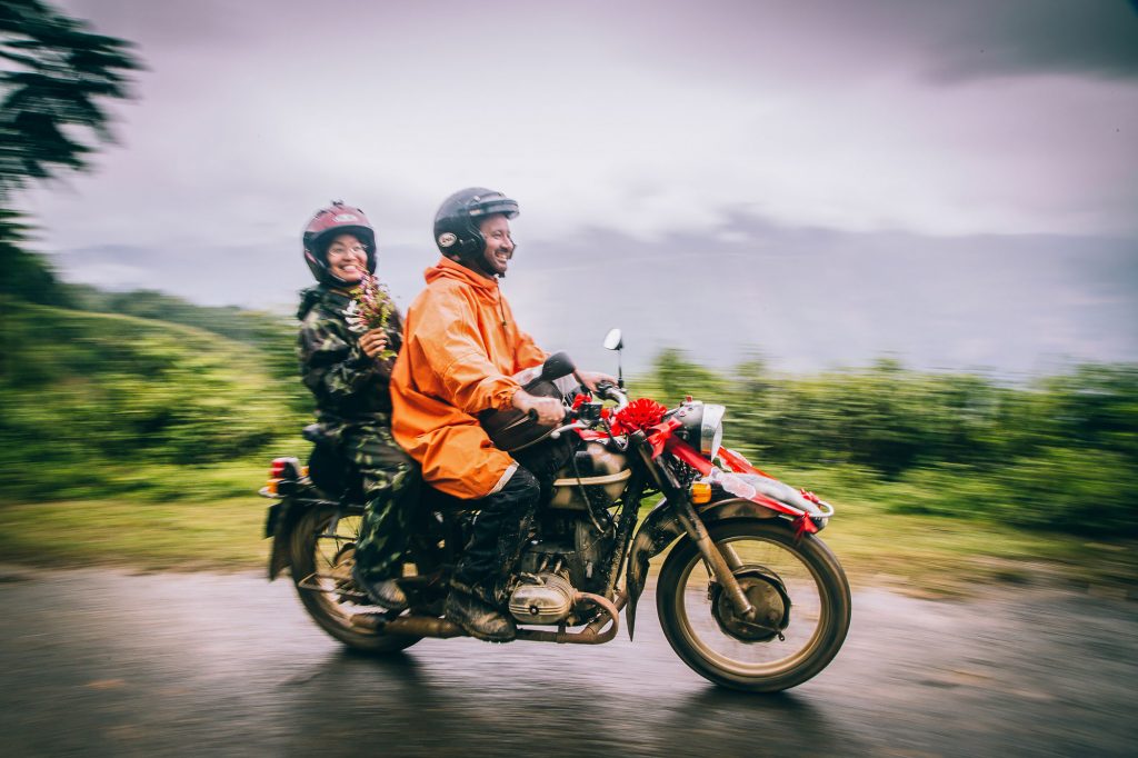 bride and groom on motorbike on way to the vietnam wedding
