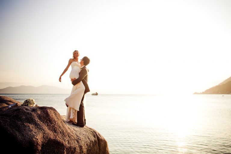 bride and groom pose on rocks at six senses hideaway ninh van bay nha trang vietnam