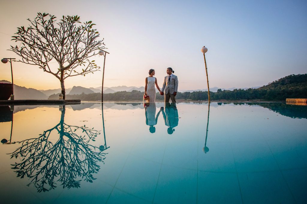 bride and groom standing by the swimming pool in luang prabang laos
