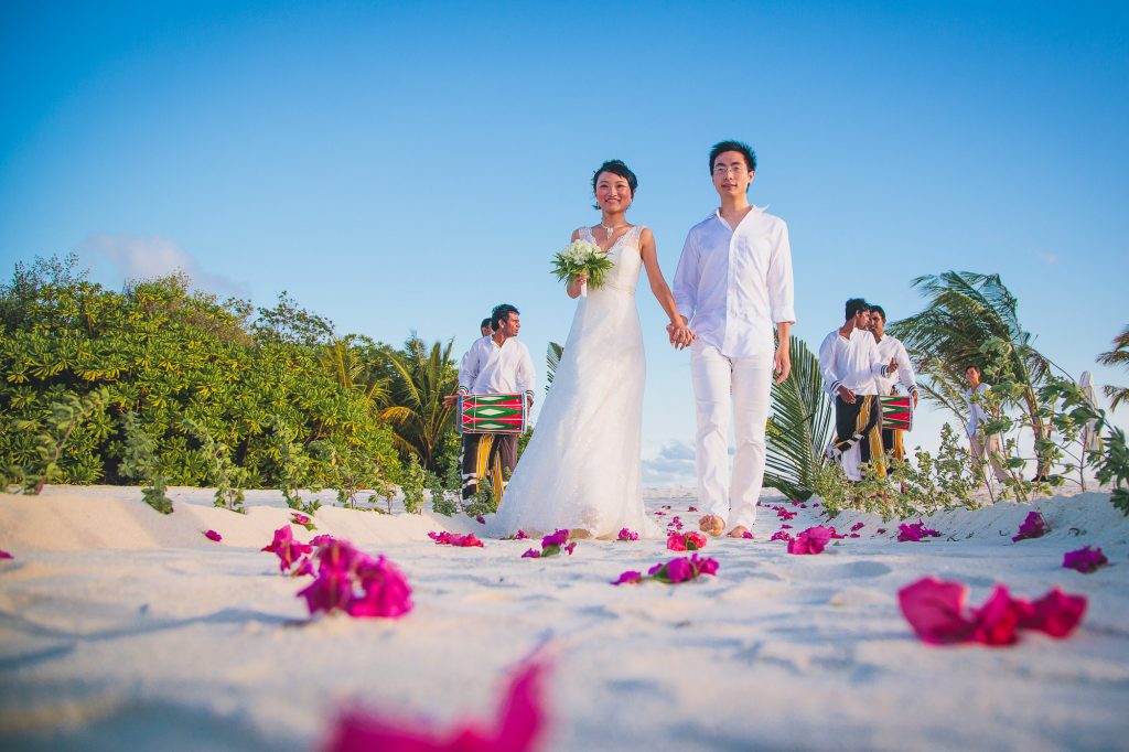 bide and groom walk down the aisle at six senses kanuhura maldives wedding