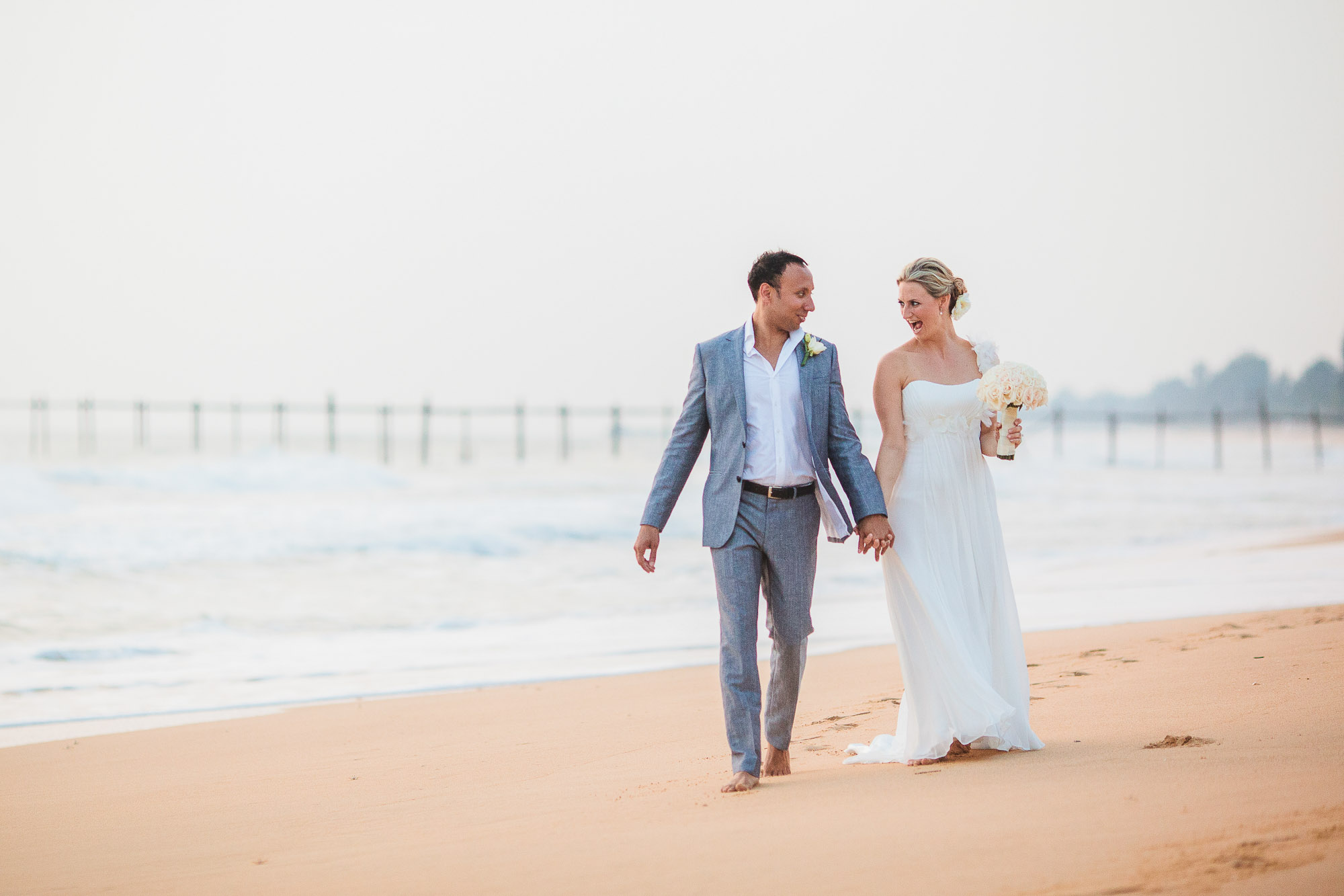 bride and groom walk down the beach at Sava Villa Natai Beach Phang Nga Thailand